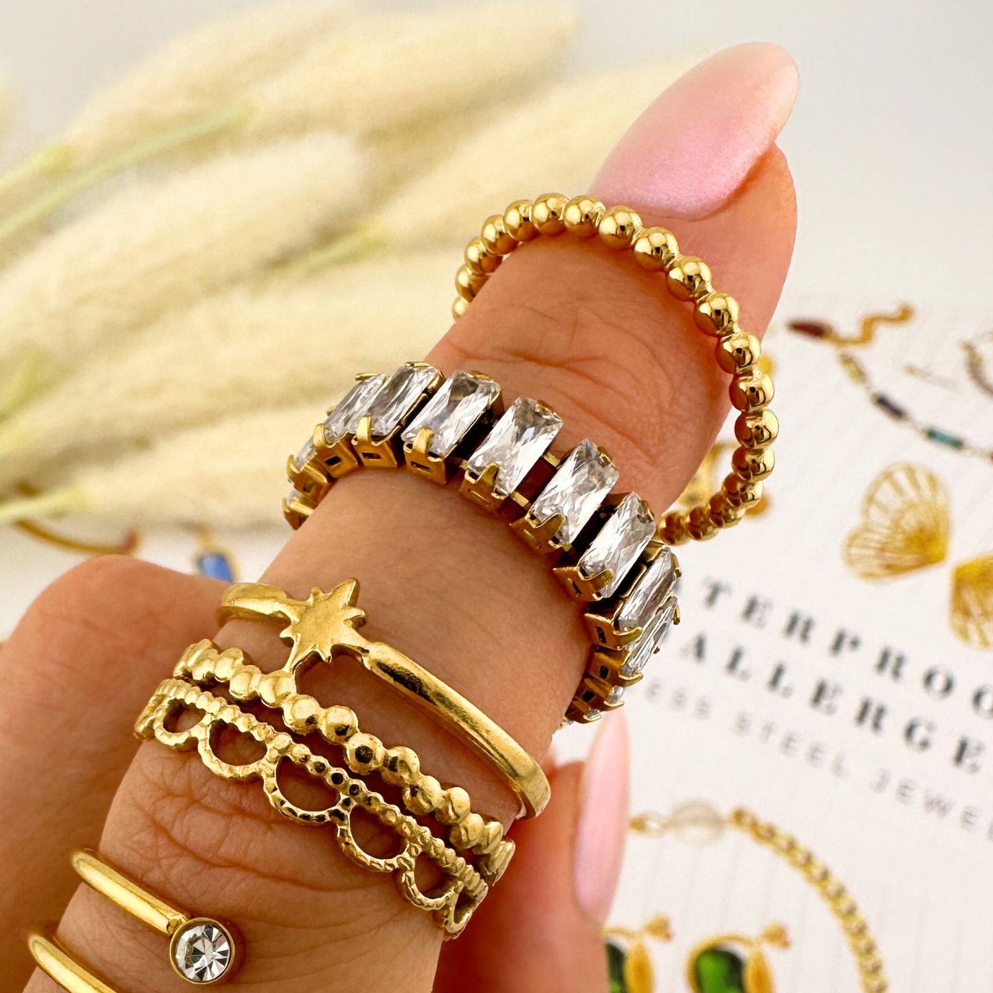 Hand wearing multiple gold and silver rings with a blurred background