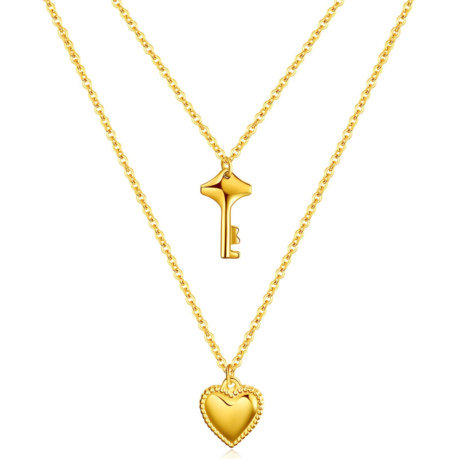 Two gold necklaces with a key pendant and a heart pendant on a white background