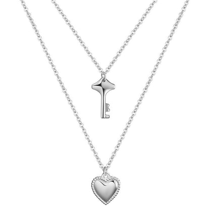 Silver key and heart-shaped pendant necklace on a white background