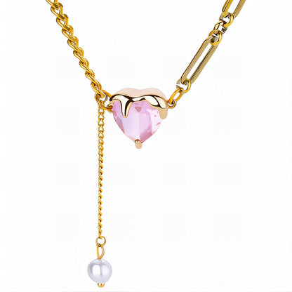 Gold necklace with a pink heart-shaped gem and pearl on a white background